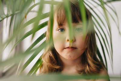 Portrait of girl amidst leaves at home