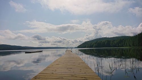 Scenic view of pier over lake against sky