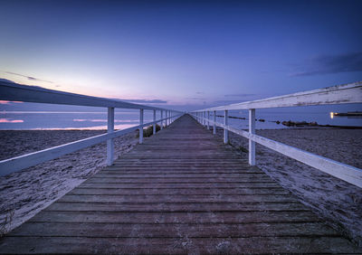 Pier over sea against sky during sunset