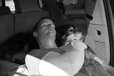 Man with dog sleeping in caravan