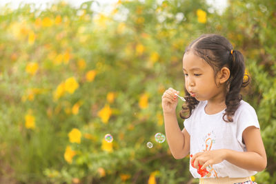 Girl looking away while standing outdoors