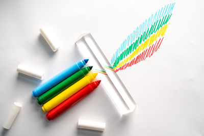 High angle view of colored pencils on white background