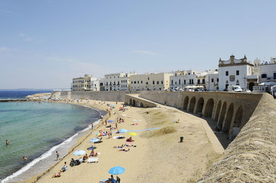 Panoramic view of people at beach against sky