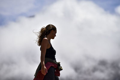 Low angle view of woman standing against sky