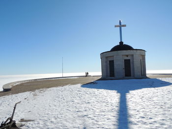 Church by building against clear blue sky