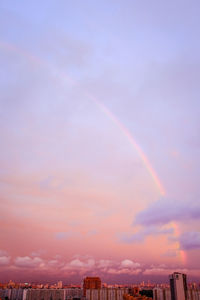 Low angle view of rainbow over buildings in city