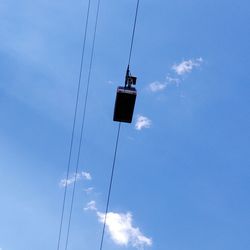 Low angle view of overhead cable car against sky