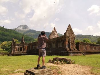 Rear view of man photographing old ruins