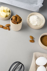Brownie recipe ingredients and kitchen utensils on gray background, top view.