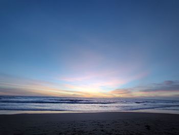 Scenic view of beach against sky during sunset