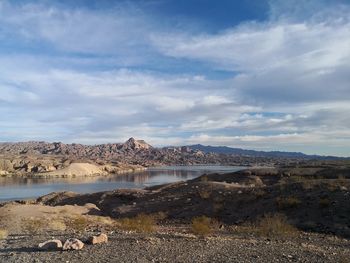 Scenic view of lake by mountain against sky