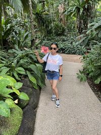 Portrait of woman standing against plants