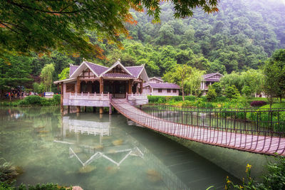 Footbridge over pond leading towards pagoda at park