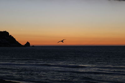 Scenic view of sea against orange sky