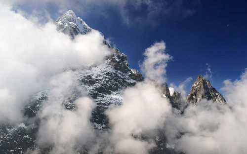 Low angle view of snowcapped mountains against sky