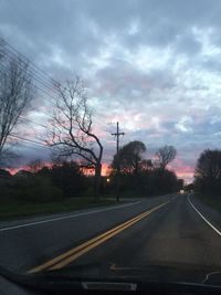 Empty road against cloudy sky