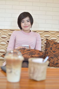 Portrait of a smiling girl sitting on table