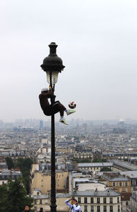 Man hanging on street light