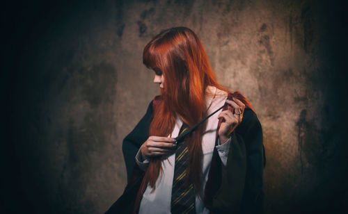 Young woman standing against wall