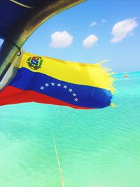 Close-up of flag in sea against sky