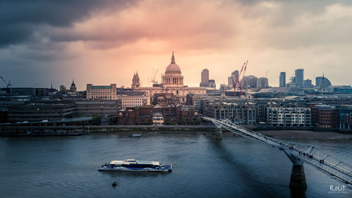 View of buildings in city against cloudy sky