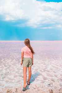 Rear view of woman standing on beach