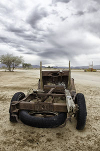 Abandoned vehicle on field against sky