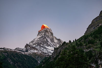 Low angle view of snowcapped mountain against clear sky