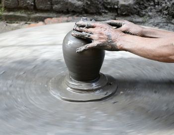 Close-up of person hand in mud