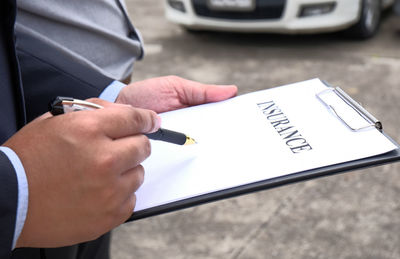 High angle view of man signing insurance form