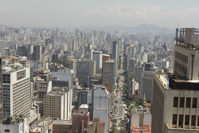 Aerial view of buildings in city against sky