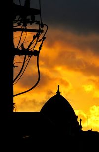 Low angle view of silhouette building against sky