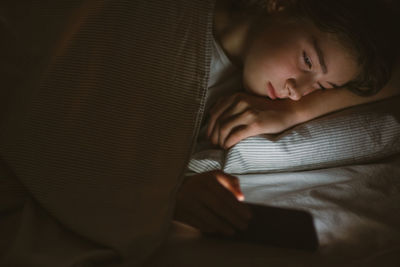 High angle view of woman sitting on bed at home