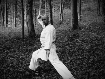 Portrait of young man practicing karate in forest