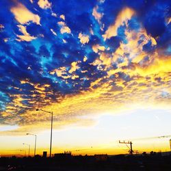 Silhouette landscape against dramatic sky during sunset