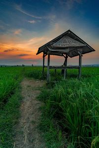 Gazebo on field against sky during sunset