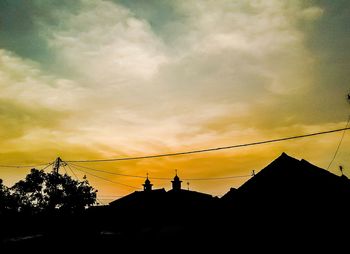 Low angle view of silhouette trees against sky