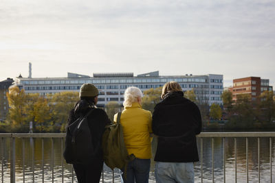 Rear view of friends standing at river