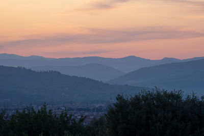 Scenic view of silhouette mountains against sky at sunset