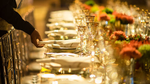 Cropped hand of waiter arranging table at restaurant