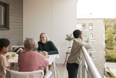 Family sitting at table on balcony