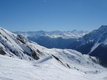 Scenic view of snowcapped mountains against clear blue sky