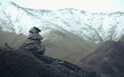 Stack of stones against snowcapped mountain
