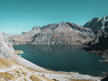 Scenic view of lake and snowcapped mountains against clear sky