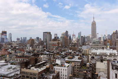 View of cityscape against cloudy sky