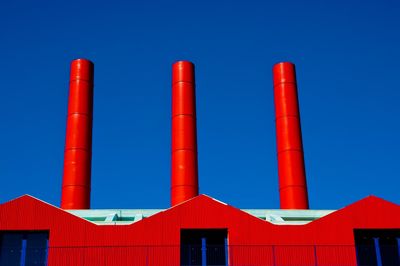 Low angle view of smoke stack against blue sky