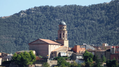 Buildings in city against mountains