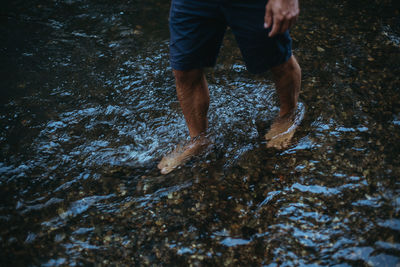 Low section of man sanding in river