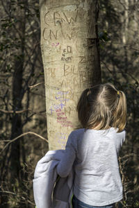 Man standing on tree trunk in forest