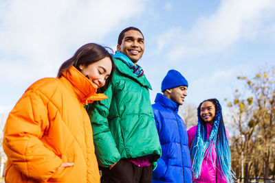 Portrait of smiling friends standing against snow